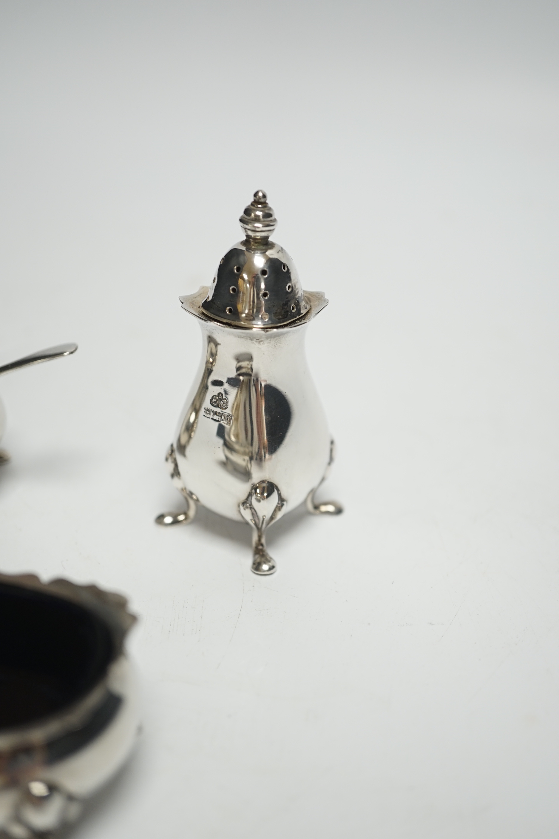 A Elizabeth II three piece silver condiment set by Elkington & Co, Birmingham, 1964/65, with associated silver spoon.